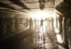 Silhouetted people standing in a concrete tunnel