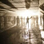 Silhouetted people standing in a concrete tunnel