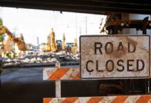 Bulldozers Roll — Cartel Crossings Spur Quiet Buildout Road closed sign at construction site under overpass