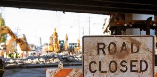 Road closed sign at construction site under overpass