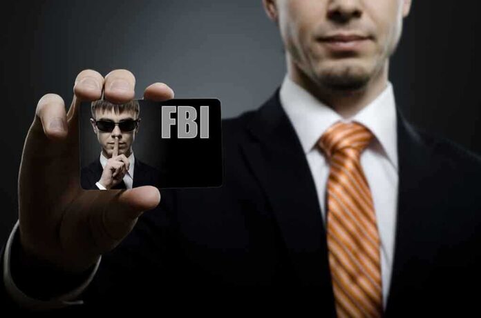 shutterstock_98237726 A man in a suit holding an FBI identification card while making a shushing gesture