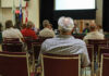 Audience members seated facing a presentation screen