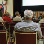 Audience members seated facing a presentation screen