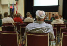 Audience members seated facing a presentation screen