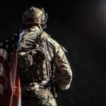 Soldier in tactical gear with American flag over shoulder