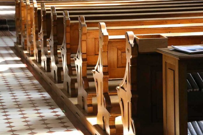 shutterstock_1152589436 wooden church pews in sunlight