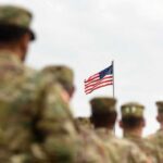 U.S. flag flying above a formation of soldiers in uniform
