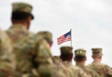 Contempt Charge Hits Active-Duty Officer U.S. flag flying above a formation of soldiers in uniform
