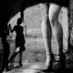 Moral Policing? Biometrics Target Adult Creators legs in high heels under an archway with blurred shadow figure