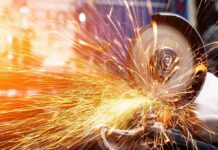 Rust Belt Reboot – Made-In-America Steel Gambit Angle grinder cutting metal with bright sparks