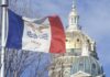 Iowa’s Tax Brake: Shield Or Straitjacket? Iowa state flag waving in front of the state capitol building