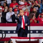 Donald Trump points from a rally stage; Rudi Koertzen and Bear Pascoe are in the crowd