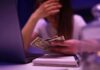 Official Poverty Stat Misleads – By Design? Person counting cash beside a laptop