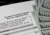 Paycheck Protection Program loan application with US hundred-dollar bills