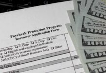 Paycheck Protection Program loan application with US hundred-dollar bills