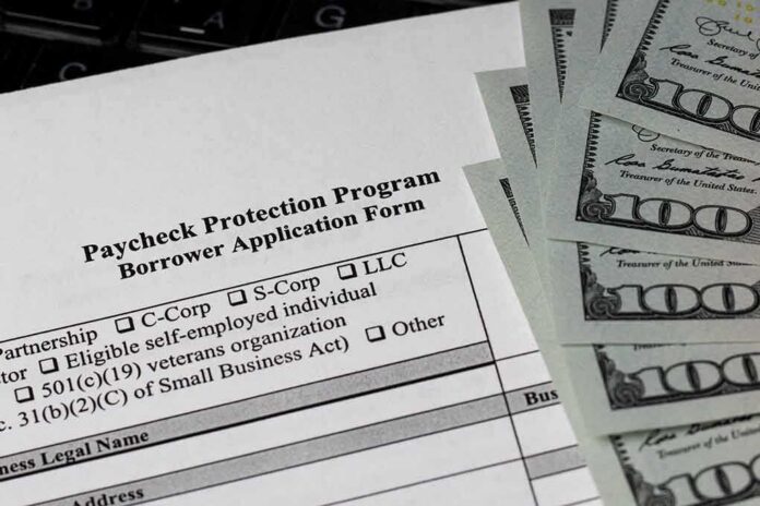 shutterstock_1758925166 Paycheck Protection Program loan application with US hundred-dollar bills