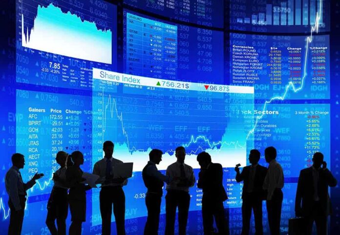 shutterstock_178709456 Silhouetted business professionals in front of digital stock market displays