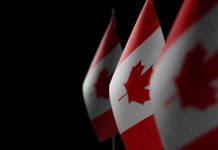 Canada’s Wild EU Upgrade – Backroom Bloc Freezes Out U.S. Canadian flags with maple leaf on dark background