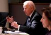 Punishment Plot? Biden’s Quiet Grudge older man in a suit speaking at a meeting table