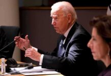 Punishment Plot? Biden’s Quiet Grudge older man in a suit speaking at a meeting table