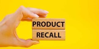 Hand holding wooden blocks reading product recall