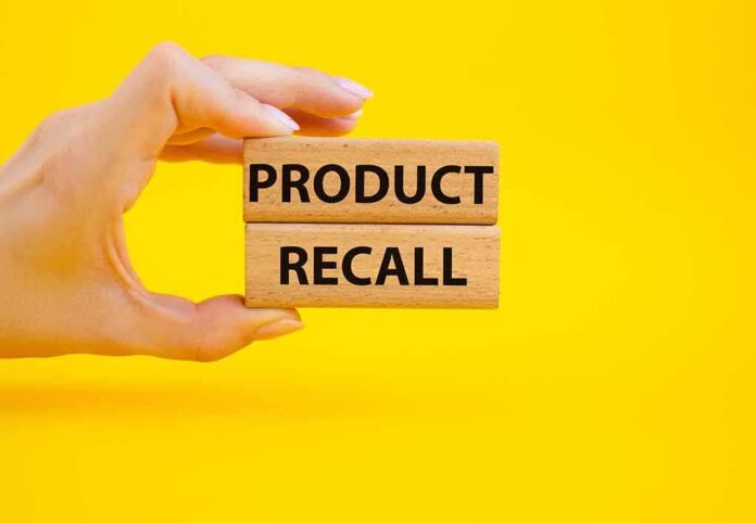 Hand holding wooden blocks reading product recall