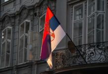 Term Limits Dodged – Leader Quits To Rule Anyway Serbian flag on a building facade