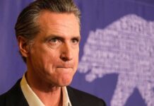 Newsom’s Radical Shift—Capitalism ‘Broken’ man in suit with serious expression