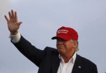 Donald Trump waving in a red cap