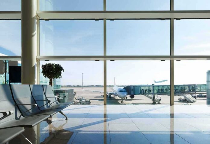 Airport terminal with plane at gate viewed through large windows