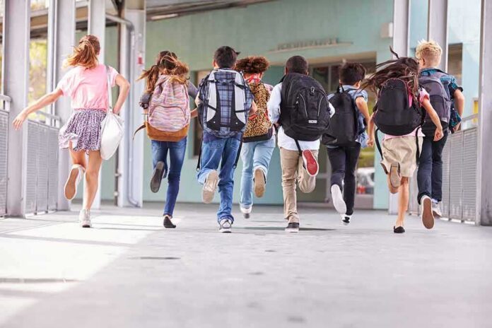 group of schoolchildren running with backpacks