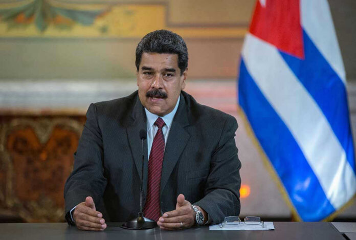 1102291202-1 Nicolás Maduro speaking at a podium with a microphone