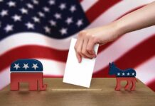 Hand casting ballot between Republican elephant and Democratic donkey