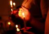 Known Black Spot – Pilgrims Don’t Make It Hands holding lit candles in a dark setting