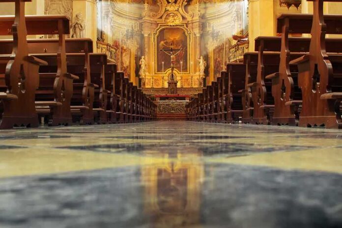 shutterstock_104146931-1 Church interior with wooden pews facing ornate altar