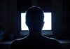 Cyberstalker Branded: Court-Mandated Risk Alert person silhouetted in front of a bright computer screen