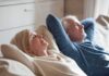 Two adults relaxing on a couch with eyes closed