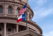 Vanished Democrat – Paxton Demands Proof Of Life Texas and U.S. flags in front of a capitol building dome