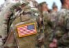 Iran Occupation Math Is Terrifying U.S. flag patch on a camouflage military uniform