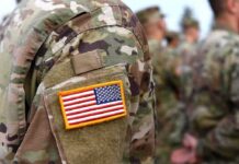 Iran Occupation Math Is Terrifying U.S. flag patch on a camouflage military uniform