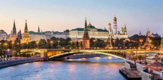 Moscow Kremlin skyline at dusk with illuminated bridge over river