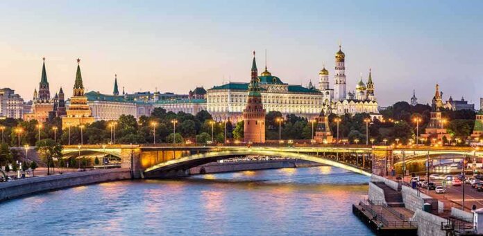 shutterstock_1419194690 Moscow Kremlin skyline at dusk with illuminated bridge over river