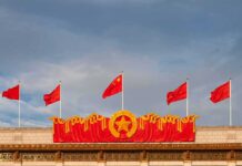 DHS Axes China Shortcut – Island Tourism Rocked Chinese flags atop a decorated building facade