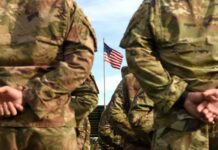 Tomahawk From Trucks? Europe Just Flinched Soldiers in camouflage stand with hands behind backs facing a U.S. flag