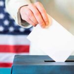 DSA Endorsements Ignite ‘Communist’ Firestorm Hand placing ballot into a box