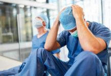 Toxic Cloud Chokes Toledo – Hospitals Fill Two exhausted healthcare workers in scrubs sit on the floor
