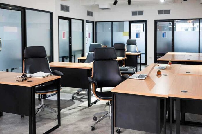 Modern open office with empty desks and black chairs