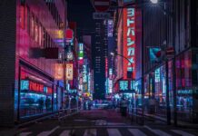Night city street with neon signs and blurred pedestrians
