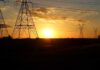 Transmission towers at sunset with power lines