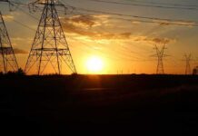 Transmission towers at sunset with power lines